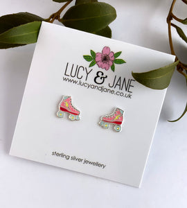 fun and colourful ear studs in the shape of roller stakes.  Colours inlcude pink and red with a yellow lightning bolt.  Photo shows the roller skate earrings on a Lucy and Jane backing card
