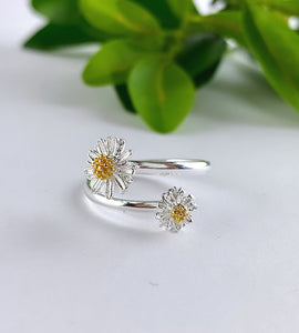 sterling silver adjustable wrap ring with a flower on either end insilver with a touch of touch of gold in the centre