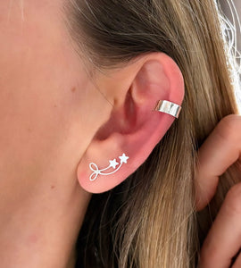 sterling silver bow and star earrings on model with silver ear cuff