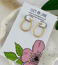 Load image into Gallery viewer, Gold oval shaped hoops on a Lucy and Jane backing card