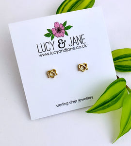 gold pretzel heart shaped ear studs, on a white backing card