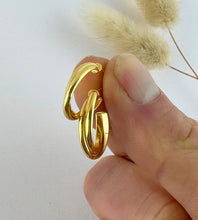 Load image into Gallery viewer, close up of a pair of gold crossover hoops