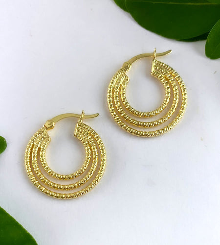 gold triple hoops that are hammered to give an striking texture