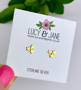 gold earrings featuring a cluster of three gold stars on each stud