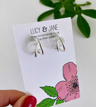 Load image into Gallery viewer, sterling silver crossover hoops on a Lucy and Jane backing card
