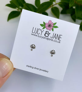 mini mushroom stud earrings in sterling silver on a branded white Lucy and Jane backing card