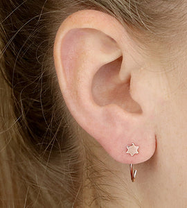 rose gold star pull through earrings on models ear