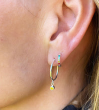 Load image into Gallery viewer, Model wears sterling silver rainbow huggie hoops with the sterling silver larger birthstone hoops with a yellow stone (for November)