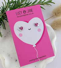 Load image into Gallery viewer, sterling silver pink sparkly heart studs with devil horns and tail. Displayed on a Valentine's card