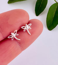 Load image into Gallery viewer, Sterling silver dragonfly earrings held between fingers with a light background