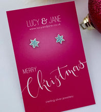 Load image into Gallery viewer, sterling silver blue frosty snowflake earrings on a merry christmas card