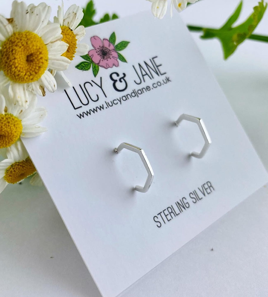 Hexagonal sterling silver half hoop earrings on a Lucy & Jane card 