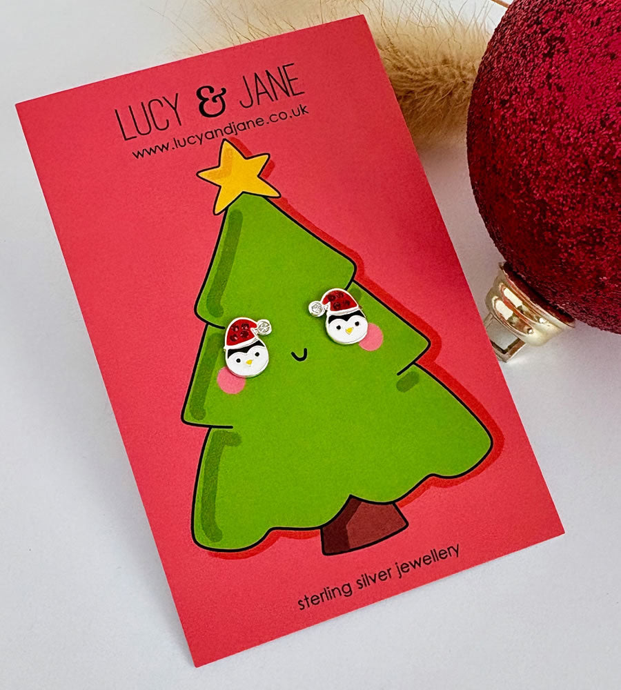 sterling silver penguin earrings wearing a sparkly santa hat on a Christmas card
