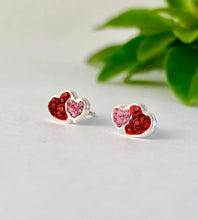 Load image into Gallery viewer, Heart-shaped stud earrings with red and pink crystals on a light background