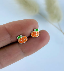 close up of the sterling silver pumpkin stud earrings. Orange pumpkin studs with a little green leaf.