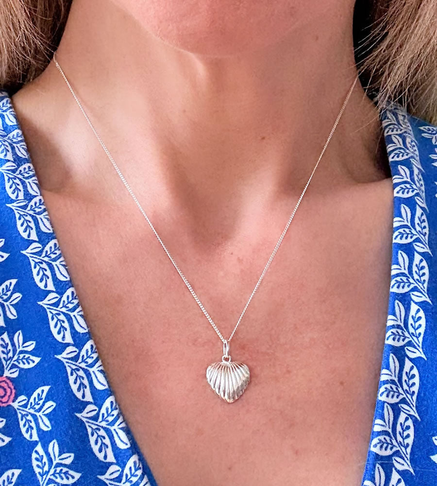 sterling silver shell heart necklace on a model's neck