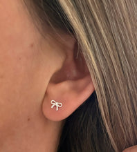 Load image into Gallery viewer, sterling silver tiny bow earrings in model&#39;s ear