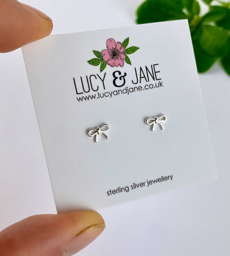 sterling silver tiny bow earrings on a Lucy and Jane backing card