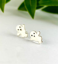 Load image into Gallery viewer, A pair of small sterling silver ghost-shaped stud earrings with white enamel and black eyes.