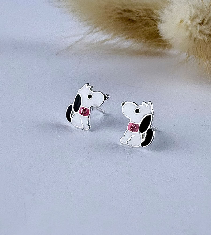 Dog-shaped earrings with pink stones on a light gray background
