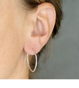 sterling silver diamond cut hoops as worn in a models ear