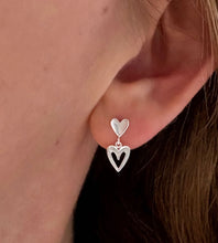 Load image into Gallery viewer, sterling silver double heart drop earrings on a model's ear