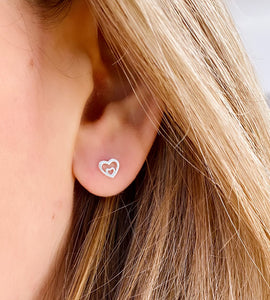 sterling silver small double heart studs on model's ear