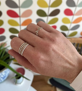 customer wears sterling silver thin twist ring stacked with the beaded ring and on the other finger wears the pretty flower ring.