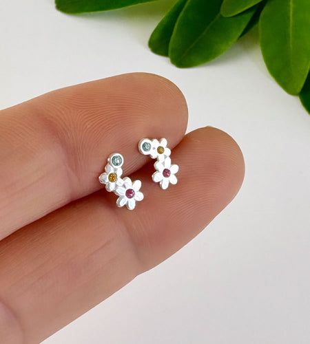 sterling silver curved flower studs with small colourful crystals at the centre