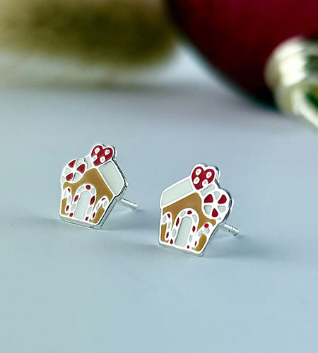 Gingerbread house earrings on a light gray background