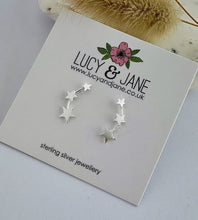Load image into Gallery viewer, sterling silver graduated star climber earrings on a Lucy and Jane backing card