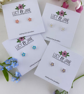 four pairs of tiny sterling silver daisy studs in different colours - white, pink, blue and purple