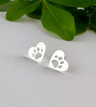Load image into Gallery viewer, sterling silver flat heart studs with a paw print cut out.  On posts with butterfly backs. Suitable earrings for children
