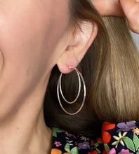 Load image into Gallery viewer, model wearing sterling silver double hoops.  Larger hoops with a smaller one set inside a large silver hoop