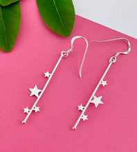 Load image into Gallery viewer, long sterling silver earrings with a long bar handing off hook earrings featuring stars of varying sizes