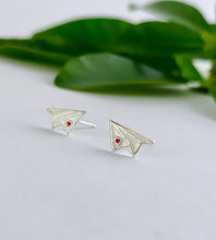 Load image into Gallery viewer, sterling siver and white paper plane earrings with a tiny red heart on the wing