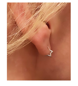 sterling silver mini star hoops in model's ear