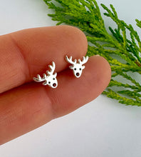 Load image into Gallery viewer, sterling silver reindeer stud earrings with tiny red crystal nose.  Held between fingers to show size