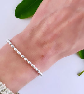 sterling silver seed bracelet on model's wrist