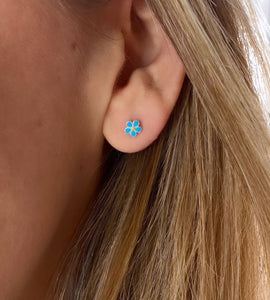 small sterling silver blue daisy studs in model's ear