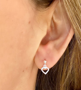 sterling silver drop heart studs in model's ear