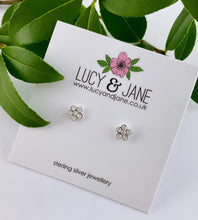 Load image into Gallery viewer, small sparkly flower sterling silver studs on a plain white backing card