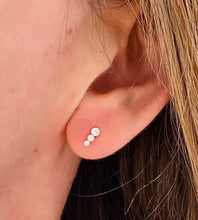 Load image into Gallery viewer, small sterling silver sparkly stud earrings on a model.