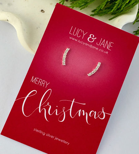 sterling silver sparkly curved bar earrings on a merry Christmas card