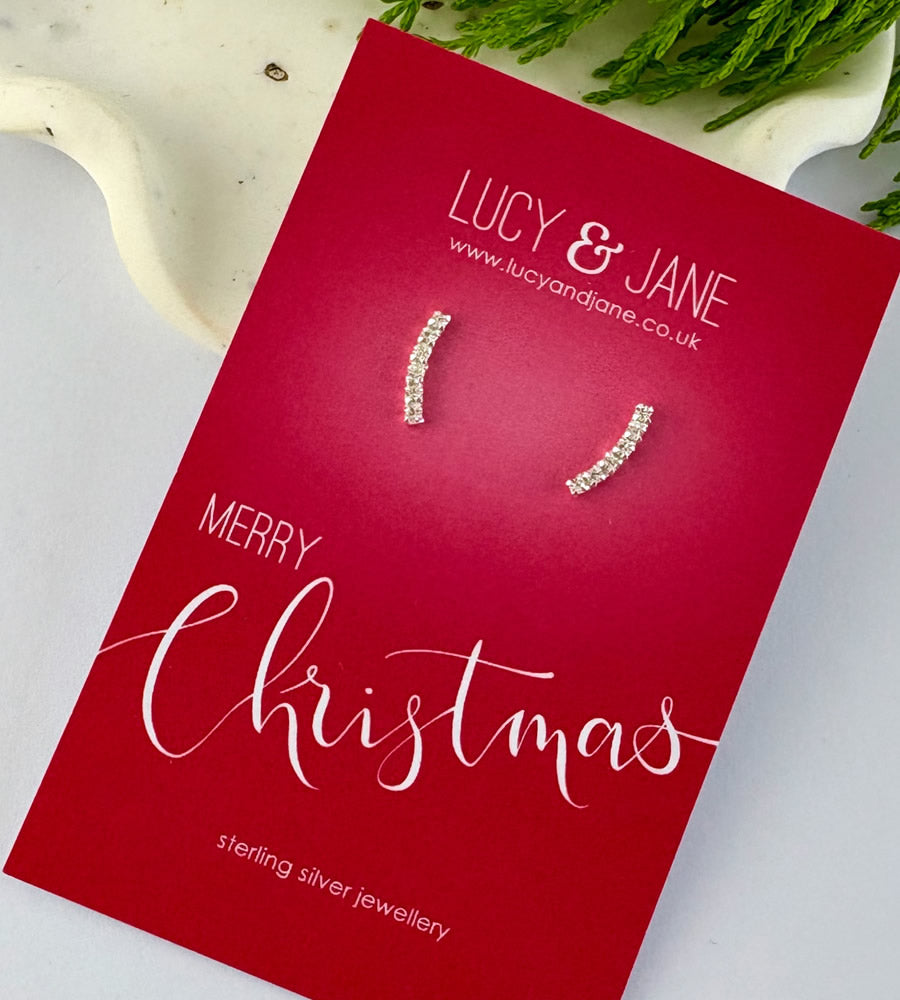 sterling silver sparkly curved bar earrings on a merry Christmas card