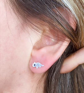 sterling silver sparkly purple triceratops studs in a model's ear
