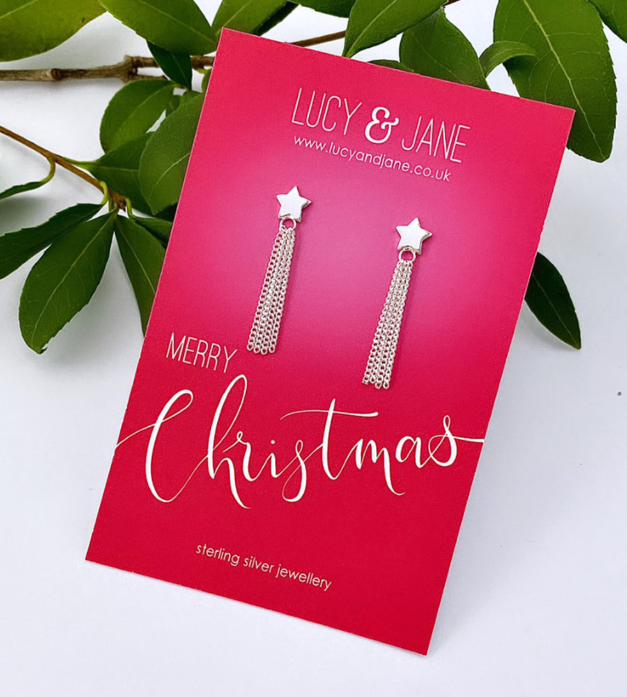 sterling silver star studs with long silver tassles hanging off them.  The long star earrings are on a Merry Christmas backing card