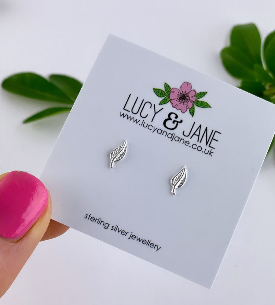 tiny sterling silver leaf studs on a branded white backing card