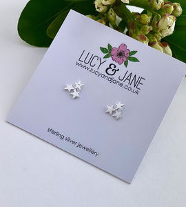 sterling silver triple star studs on a white card