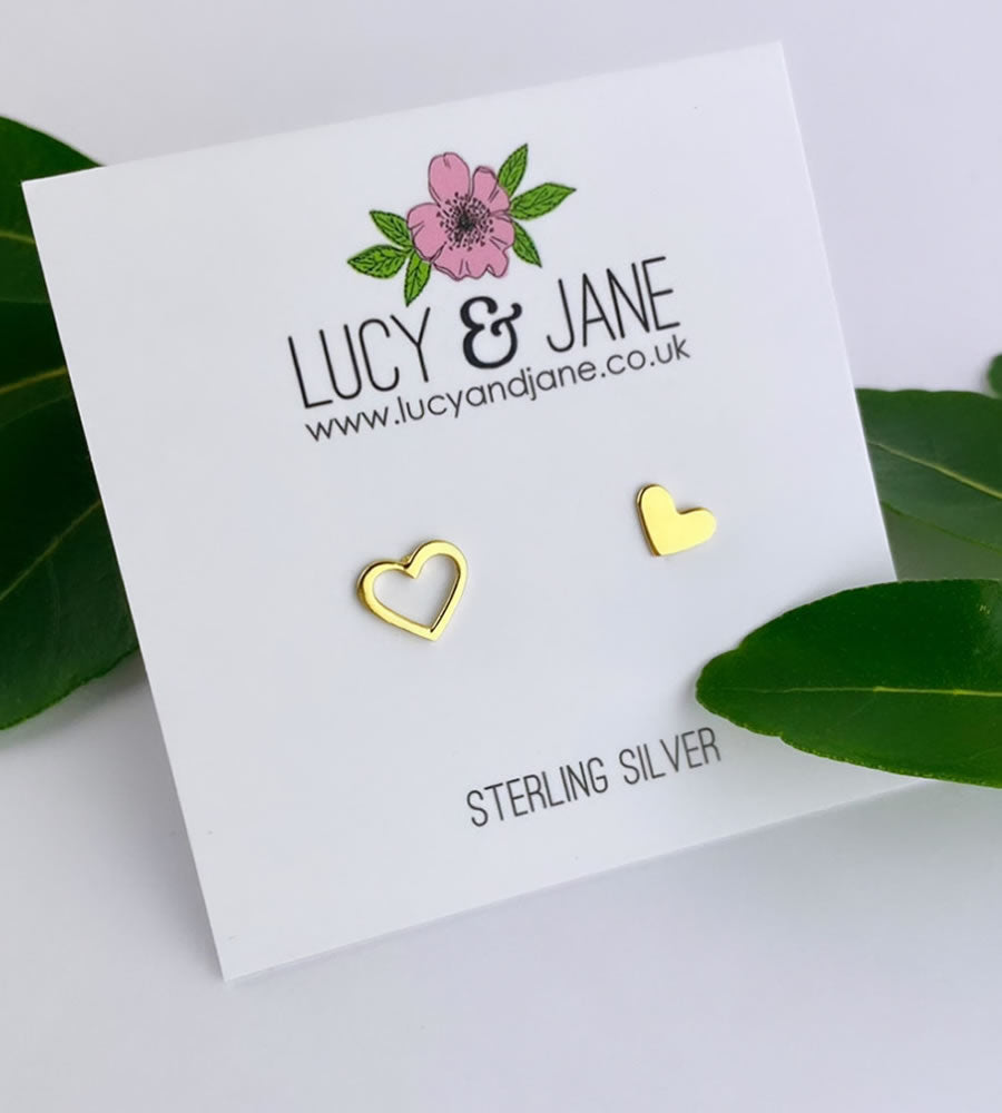 mismatched gold heart ear studs with one solid heart and one open heart stud